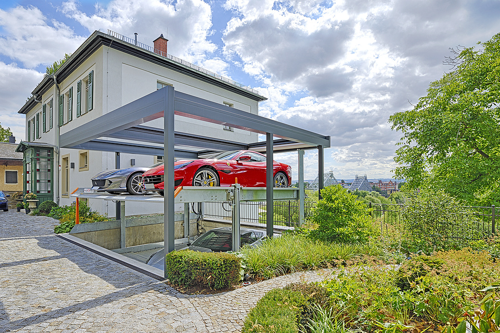 Parksystem fährt mit 2 Autos hoch. Unten erscheint ein weiteres Auto