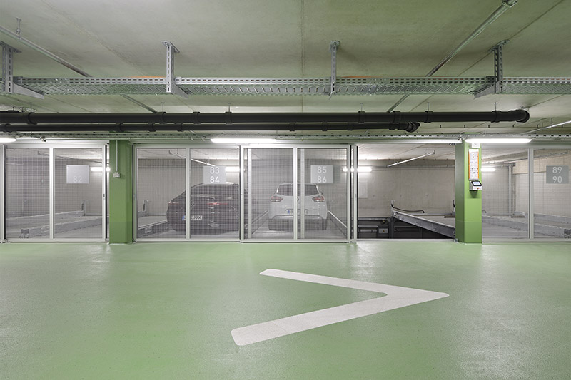 Frontsicht auf ein halbautomatisches Parksystem mit geparkten Pkw